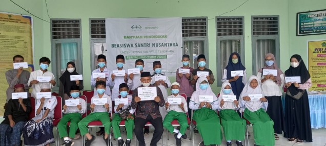"Ketua LAZISNU PWNU Provinsi Sultra, Kuat Mujabah (tengah), berpose bersama penerima beasiswa dalam program bantuan pendidikan tunai-beasiswa santri nusantara dana zakat Tokopedia. Foto Istimewa