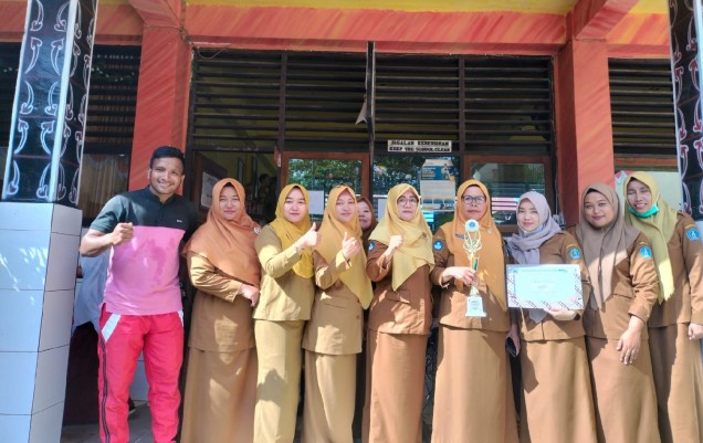 "Kepala SD Negeri 1 Kendari berpose bersama guru sambil memegang tropi juara 1 lomba gerak jalan indah tingkat Kota Kendari. Foto: Istimewa